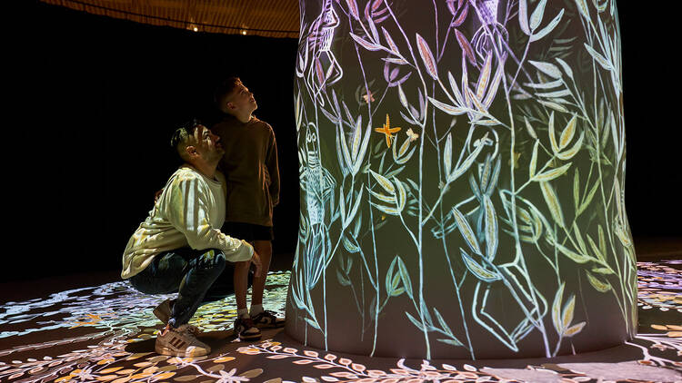 Father and son looking at a digital installation
