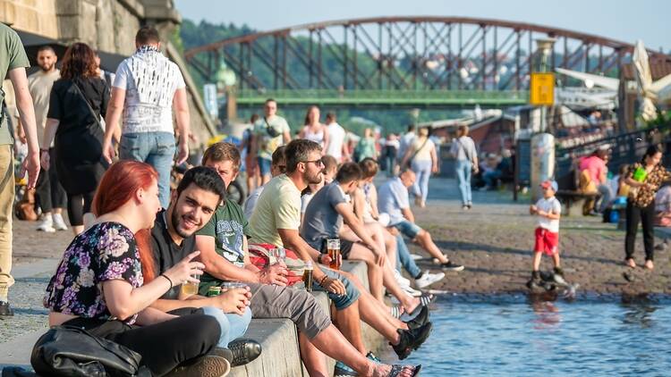 People laughing by the river in Prague