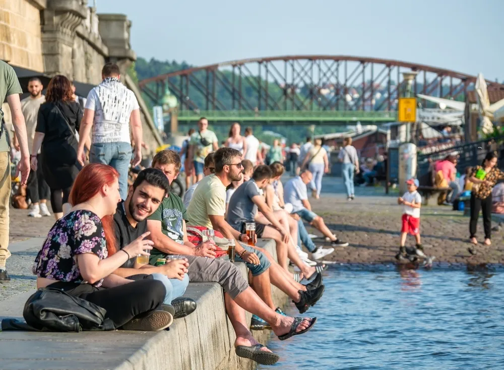 People laughing by the river in Prague
