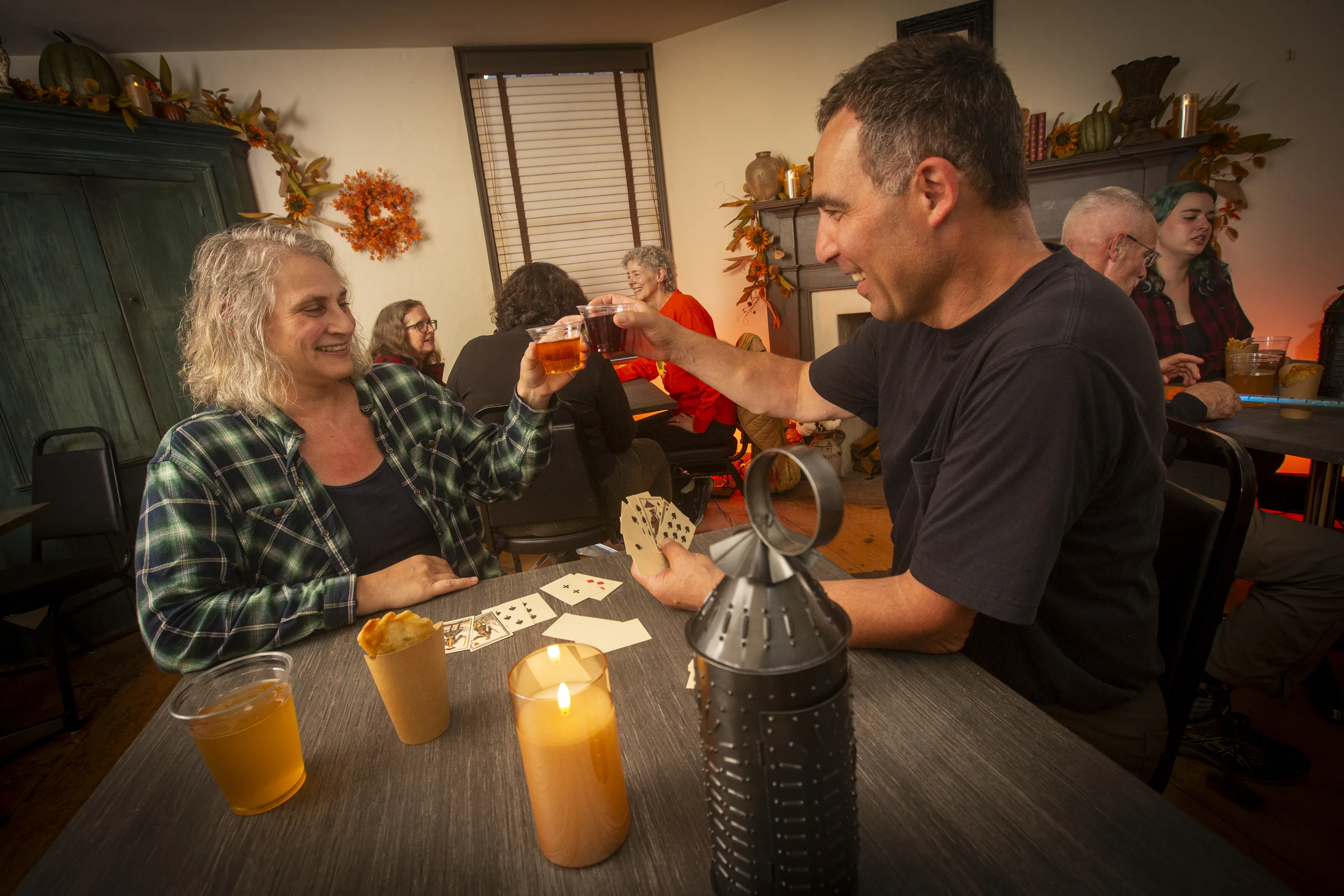People clink glasses inside an old tavern.