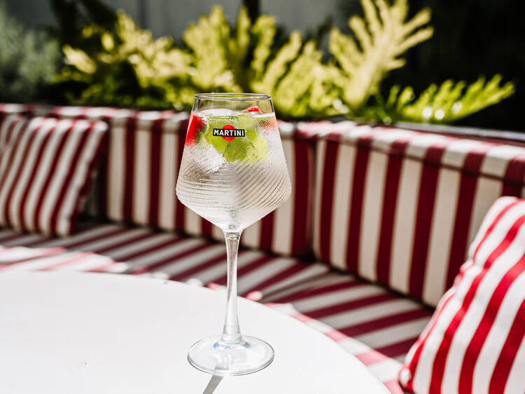 Um jardim, um cocktail na mão e Lisboa a seus pés