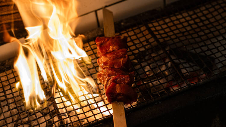 Juicy cuts of meat sizzle over open flames, their edges crisping and caramelising as the skewer slowly turns, by Pingrumba