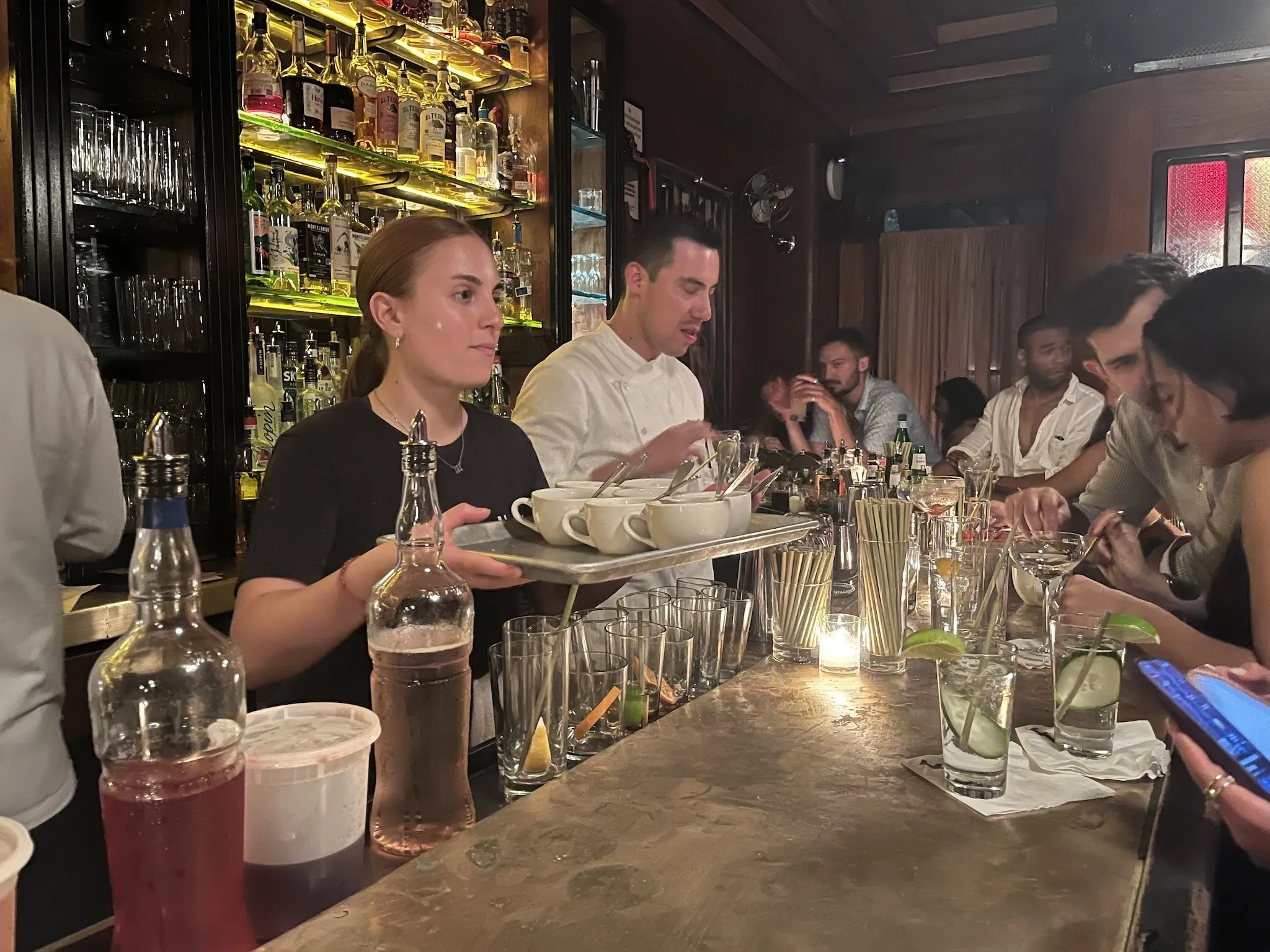 A server with a tray of soup