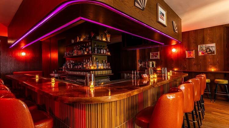 A wooden bar with purple lights at Bar Snack