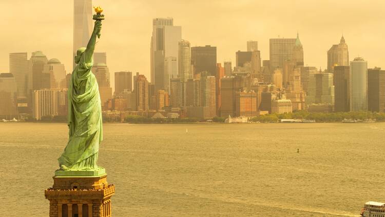 Statue of Liberty against a smoggy NYC