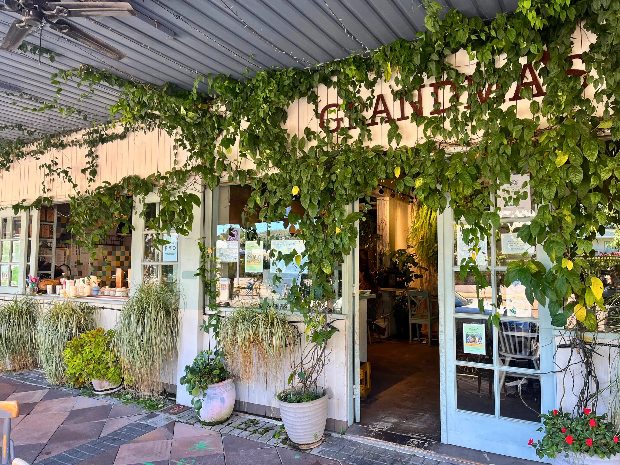 Outside of cafe with greenery and potplants