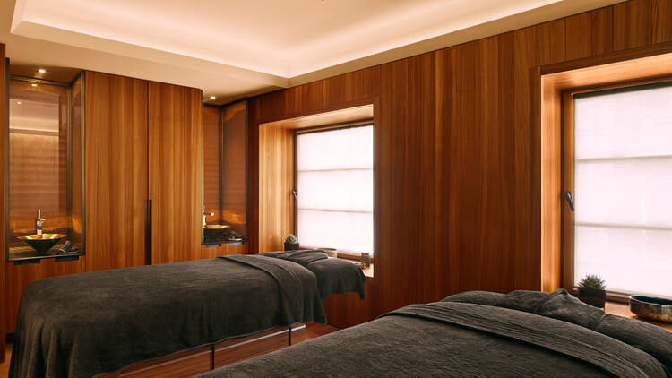 Indoor spa at Bulgari Roma, showing two massage beds against a window, with wooden walls