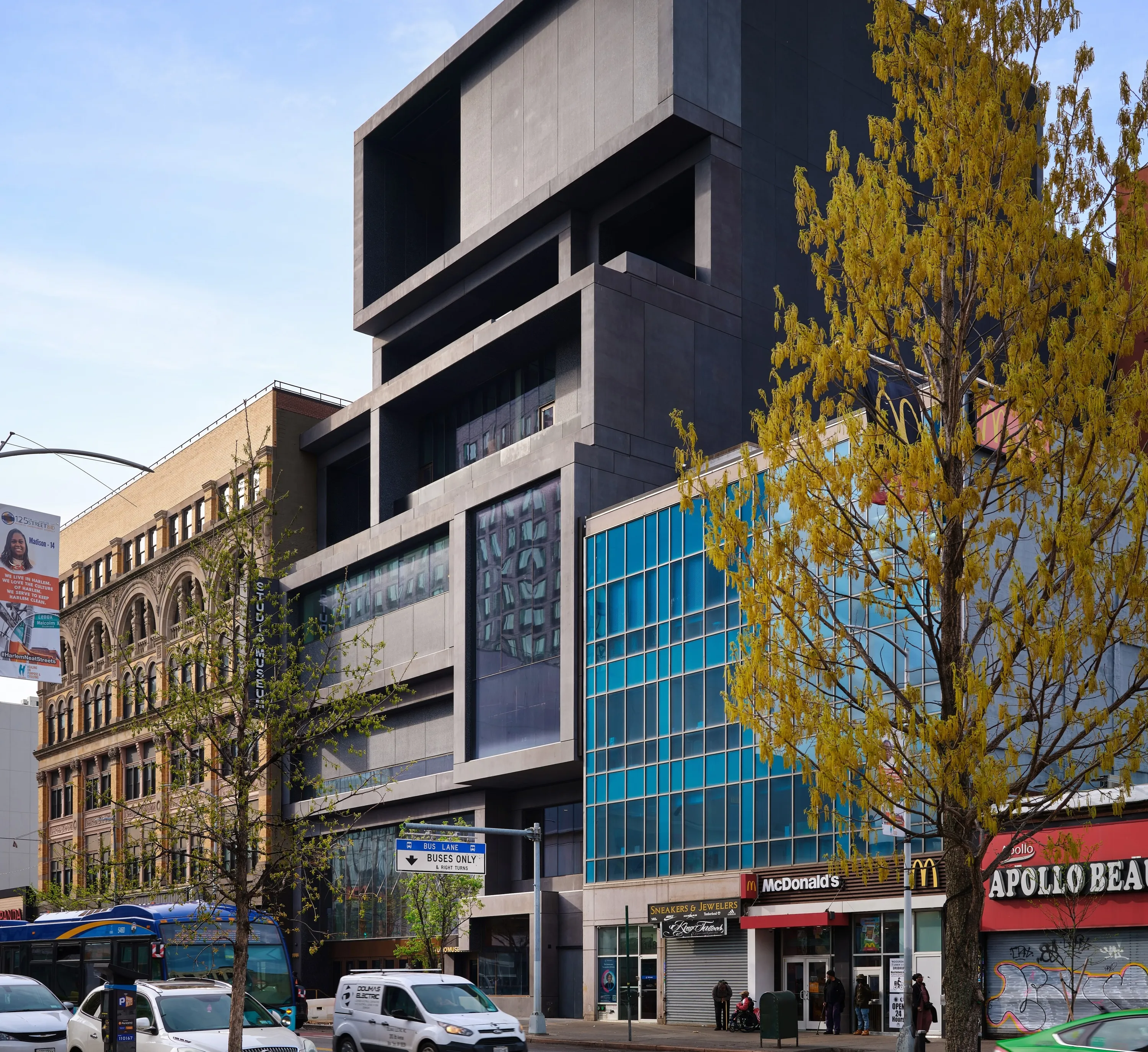 The exterior of the new Studio Museum, a black six-story structure nestled on a busy block.