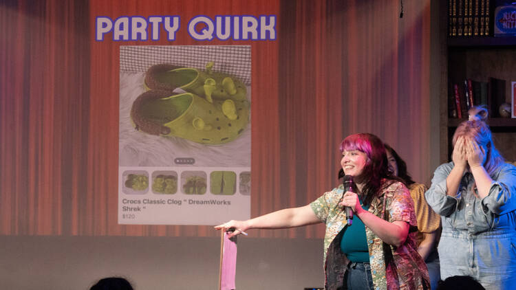 Women standing on stage in front of a slideshow picture of shoes being sold on Facebook