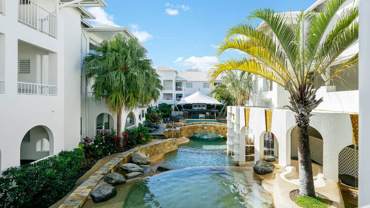 A view of a hotel overlooking a lagoon pool 