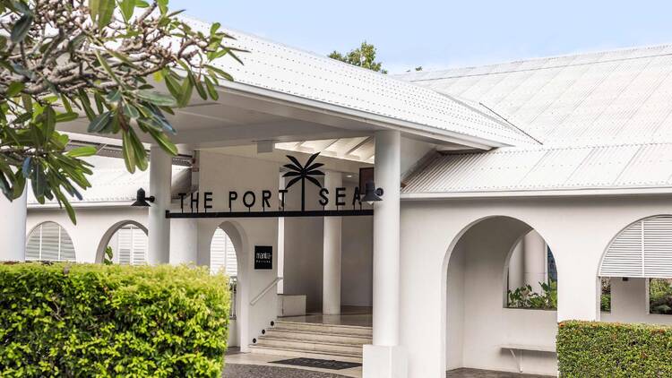 The exterior of a white hotel with archways. 