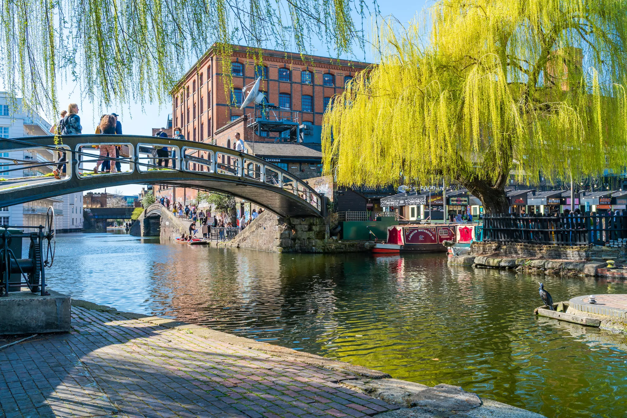 People enjoy sunny weather in Camden Lock on the bank of Regent's Canal in Camden Town in London