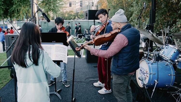 people on stage playing string instruments