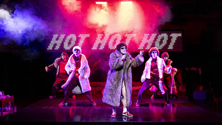 Members of Pony Cam on stage in 'The Orchard' against a backdrop that says Hot Hot Hot.