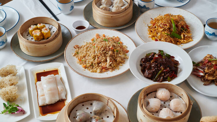 Table filled with dim sum baskets, fried rice dishes and cutley