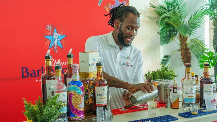 A man pours a drink at a booth.