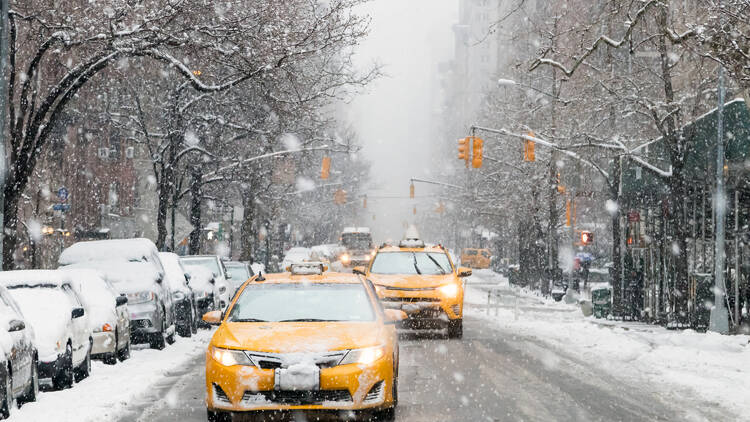 Taxis driving down snowy Manhattan streets