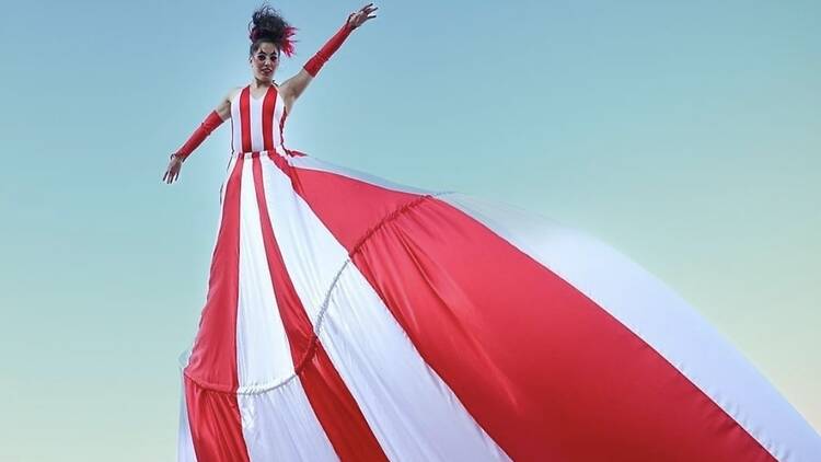 A performer in a long red-and-white outfit.