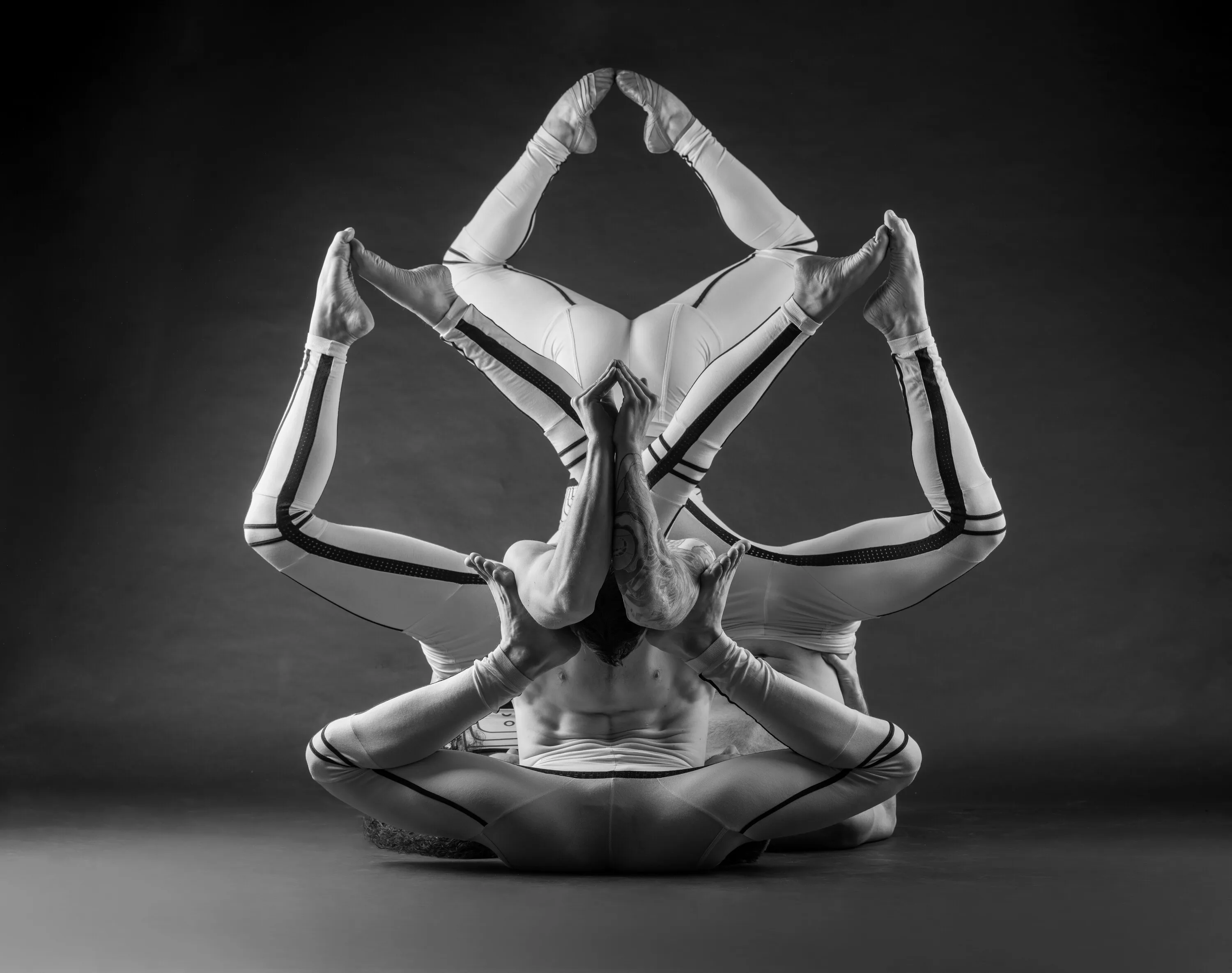 Performers link arms and legs in a diamond position.