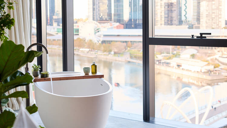 A bathtub overlooking the Yarra River at 1 Hotel Melbourne.
