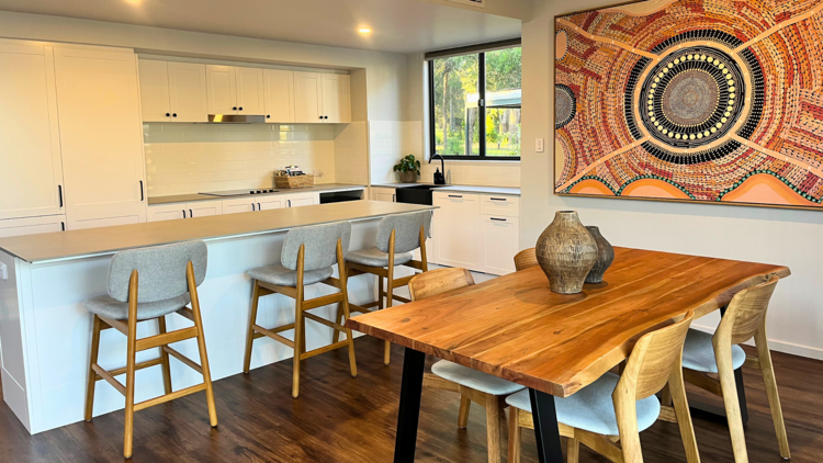 Dining room with large artwork and kitchen bench