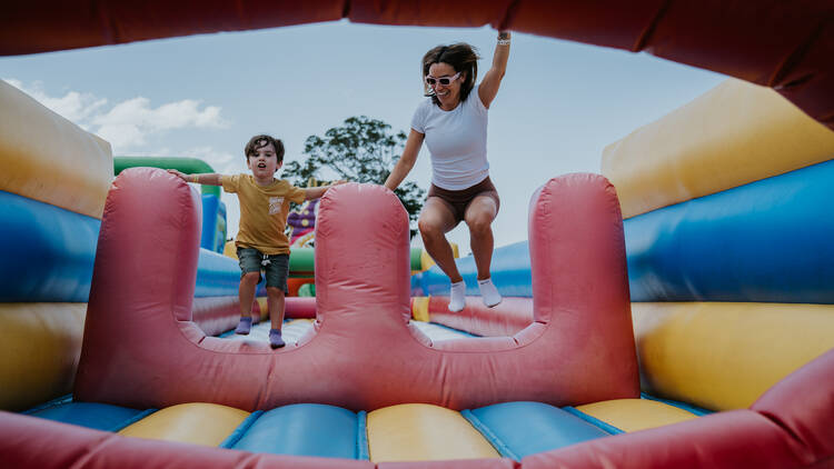 A mother and son on a huge inflatable jumping course 