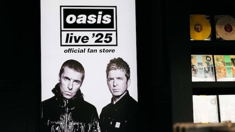 A screen displaying a black-and-white photo of Noel and Liam Gallagher.