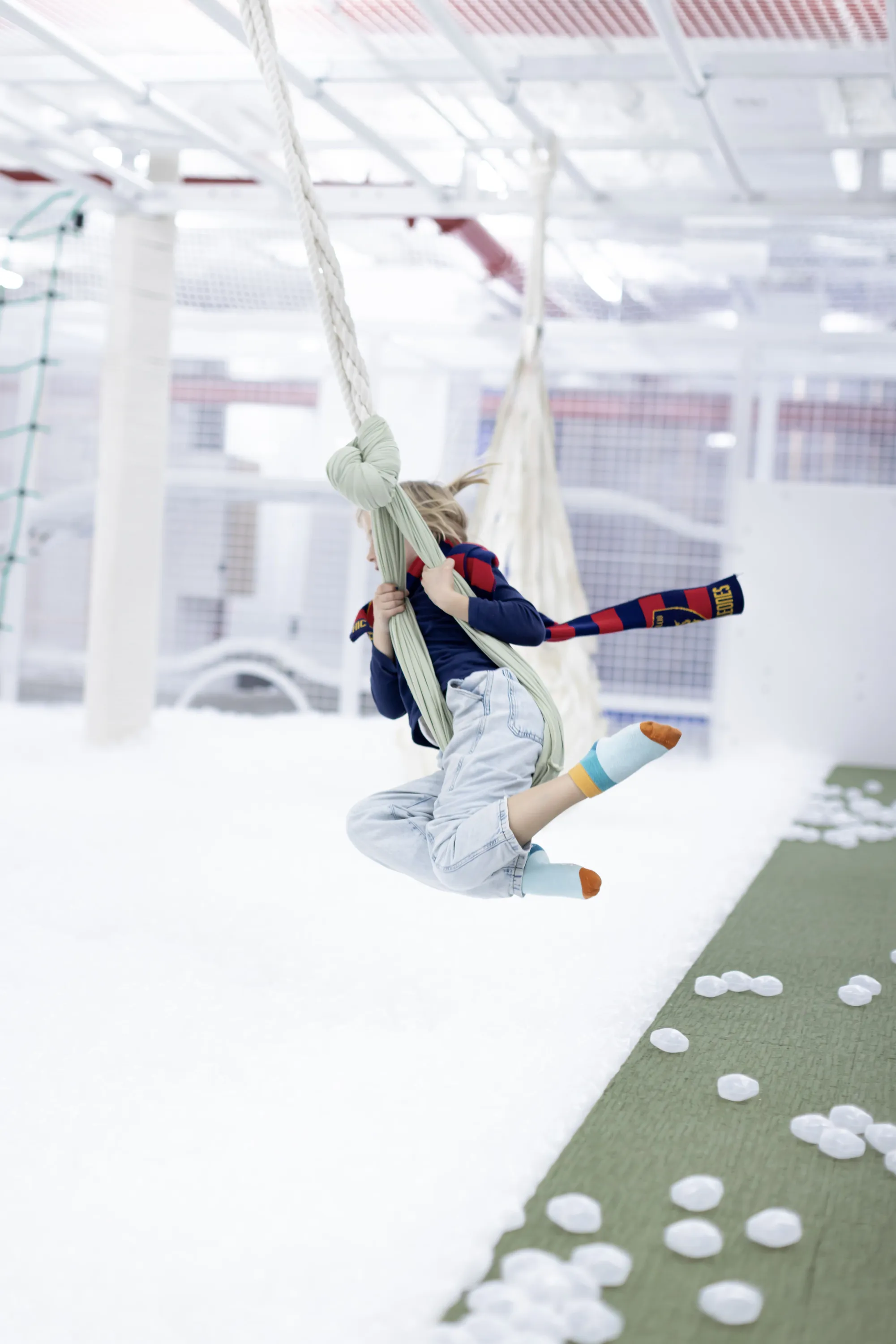 A kid swings in a playspace.