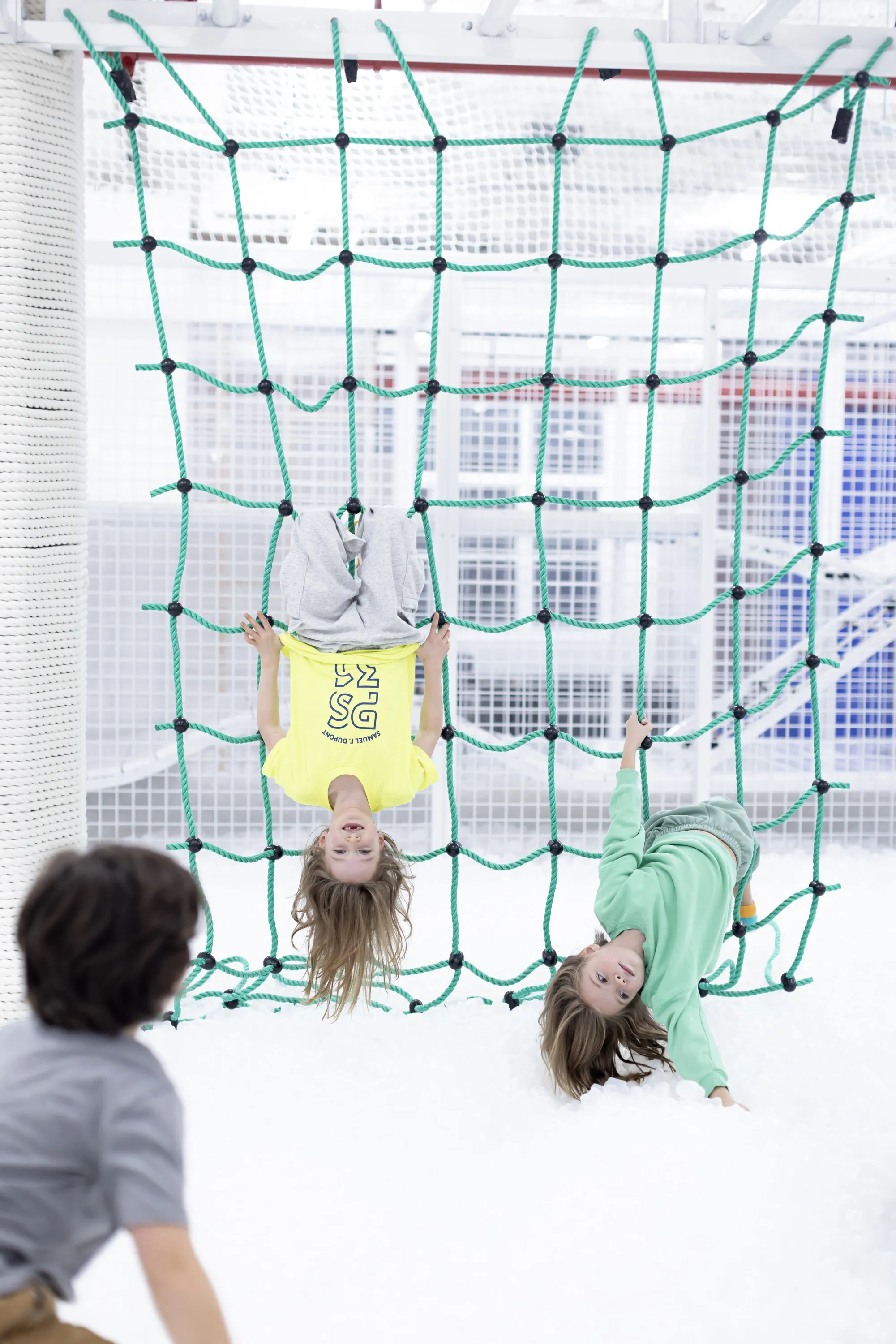 Kids hang on a rope toy.