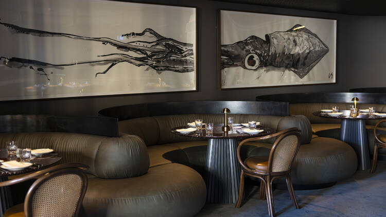 A big framed artwork of a squid on the wall above elegant seating