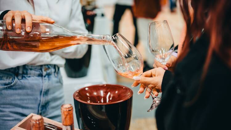 Sommelier pouring wine for wine tasting in a bar of restaurant or wine expo.	