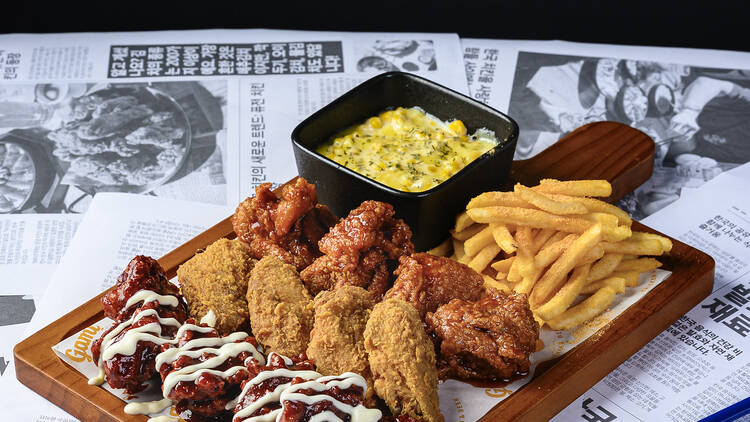 A platter of fried chicken with dips and fries.