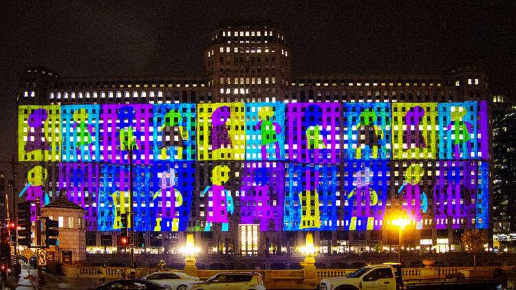 Multicolored projections paint the facade of Chicago's Merchandise Mart (THE MART).