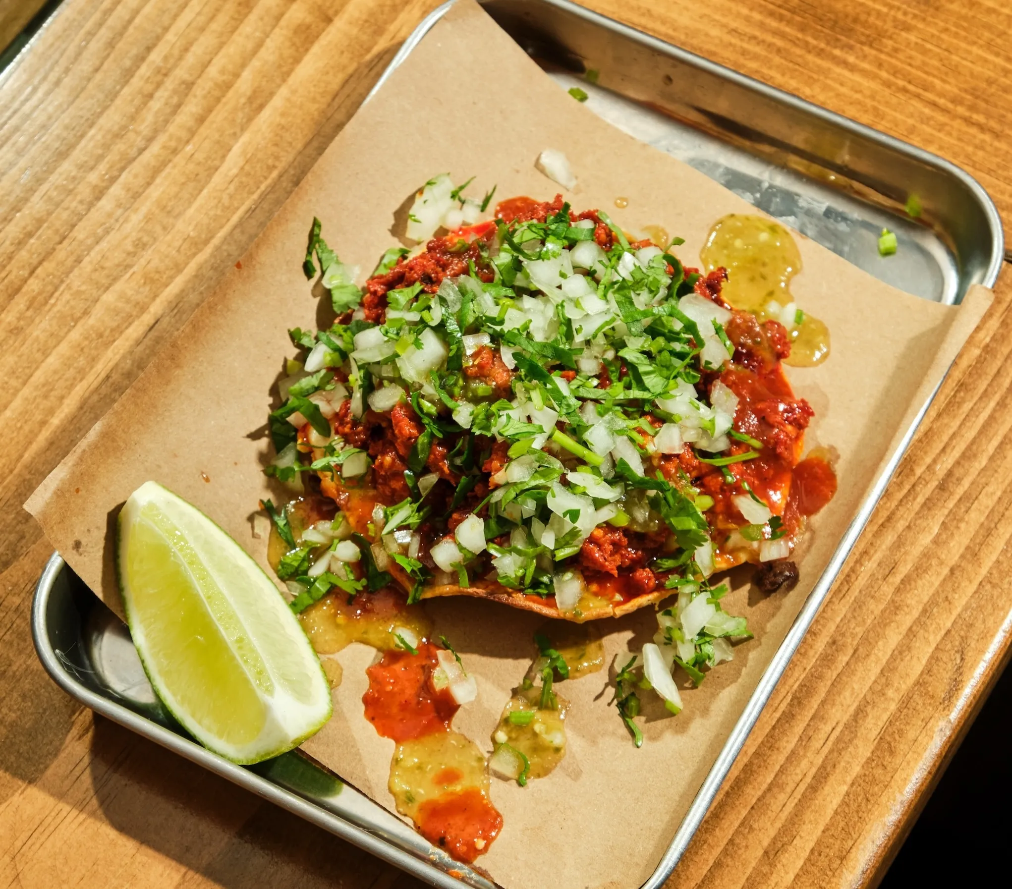 Tacos with cilantro, onions and a lime wedge