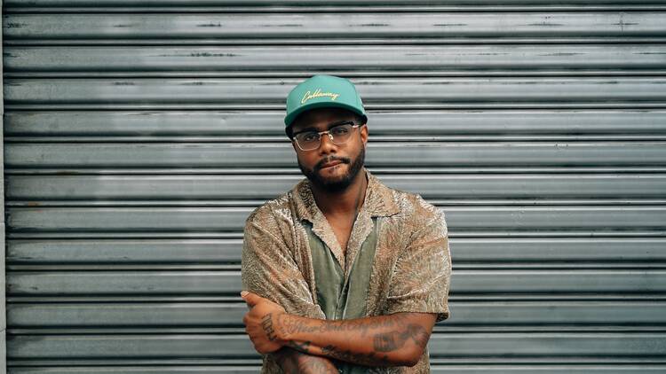 Kwame Onwuachi in front of a metal shutter