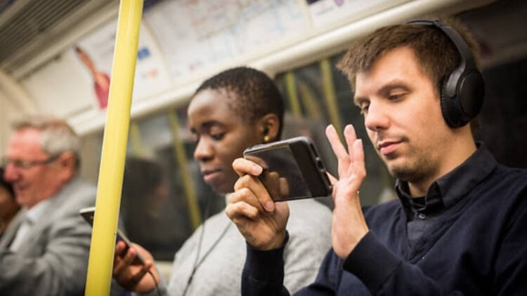 Man using headphones on tube
