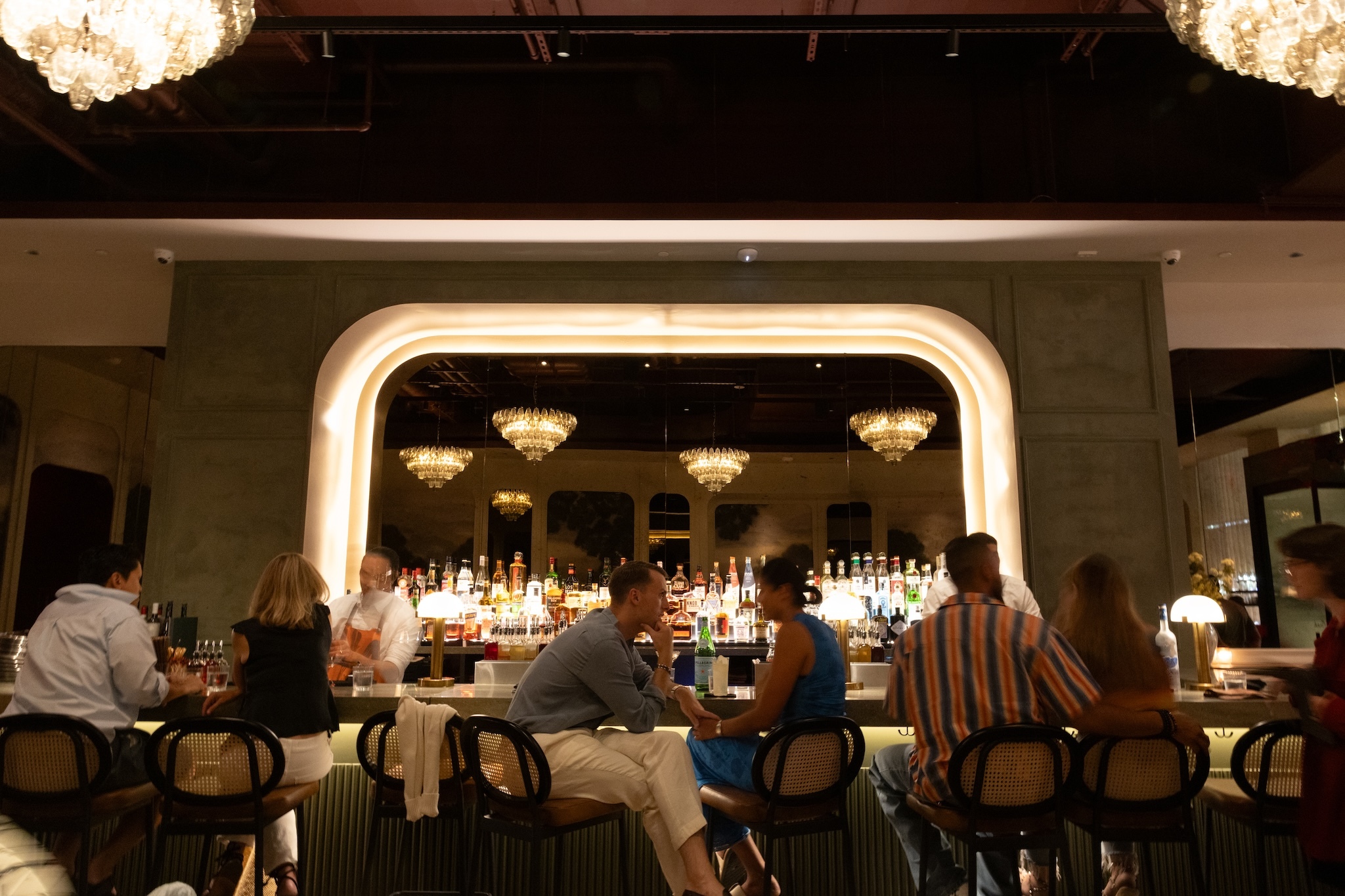 A huge illuminated mirror sits behind the bar at Markette