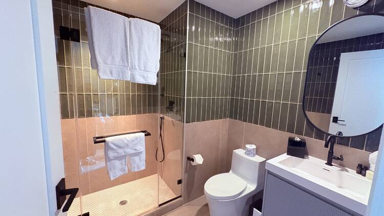 The first bathroom in the penthouse is tiled in green and beige