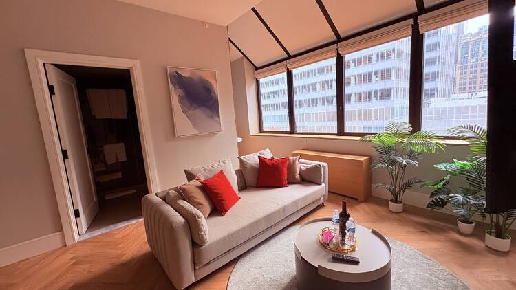 Aura Hotel Times Square's penthouse living room has windows facing south and a couch
