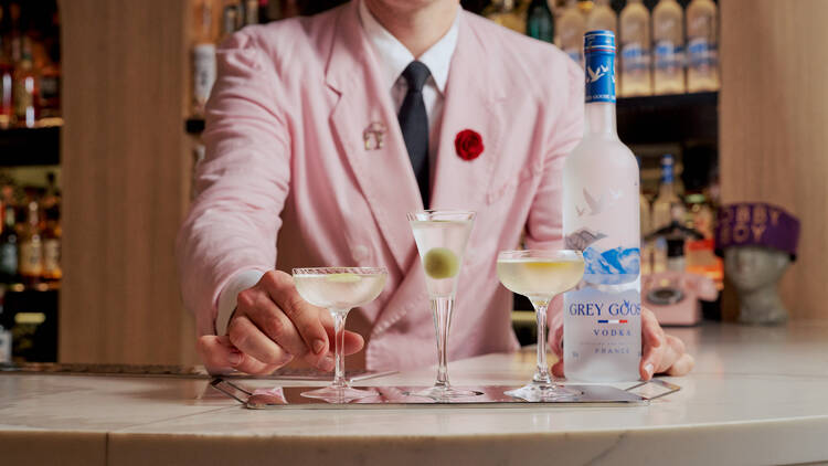 A bartender serving three Martini flights