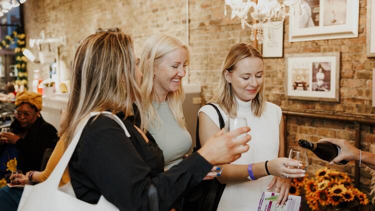 A group of people tasting wine and smiling. A group of people tasting wine and smiling.