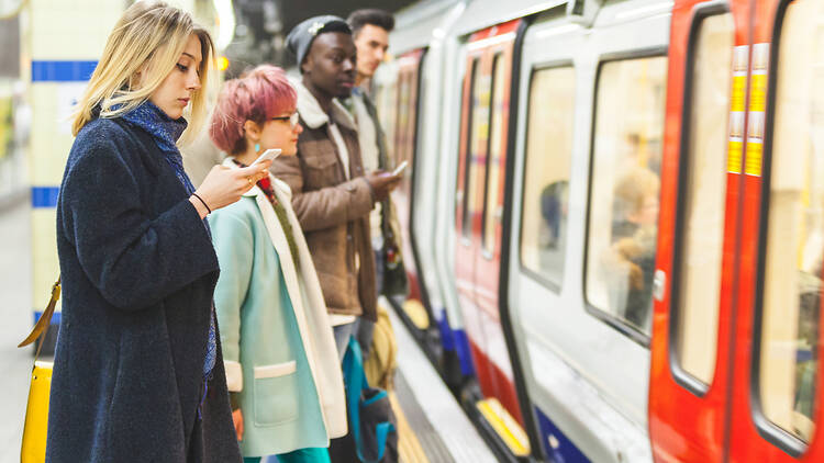Passengers waiting on the tube platform to board the train.