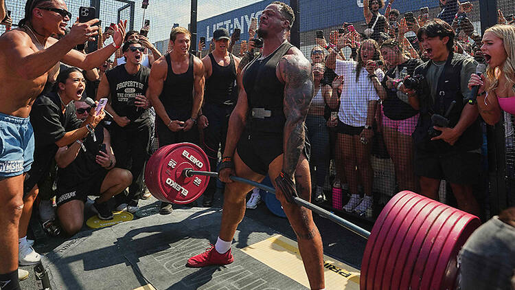Lift:LDN weightlifting event A bodybuilder deadlifts a barbell loaded with weights in a PR cage at at Gymshark event