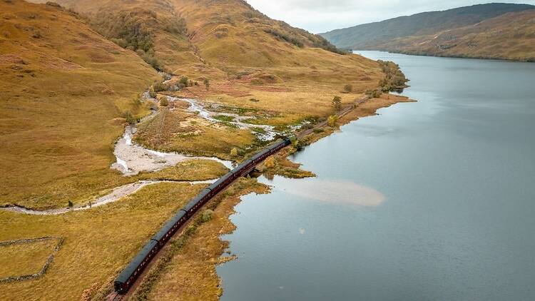 The West Highland Line in Scotland passing by a Loch.