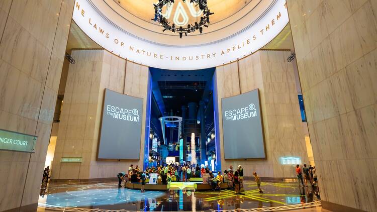 The lobby of the Griffin Museum of Science and Industry, flanked by screens reading "Escape the Museum."