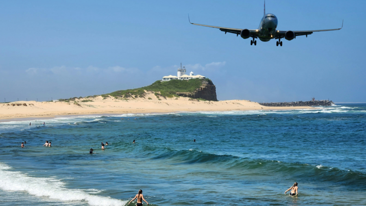 Plane in sky over beach