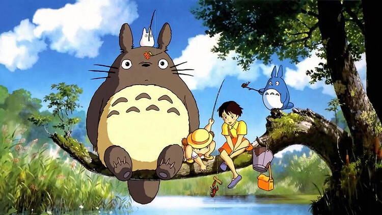 Kids sitting with furry animal Totoro from 'My Neighbor Totoro'