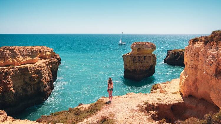 Woman standing looking at the sea in the Algarve, Portugal