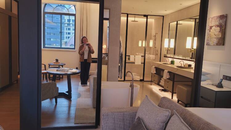 A woman taking a photo of herself in the mirror in a hotel room