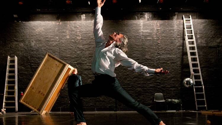 Dancer on a bar stage with only a ladder and a wooden box for staging Dancer on a bar stage with only a ladder and a wooden box for staging